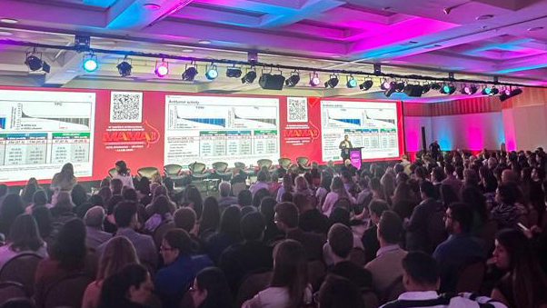 Palestra com plateia lotada e iluminacao profissional